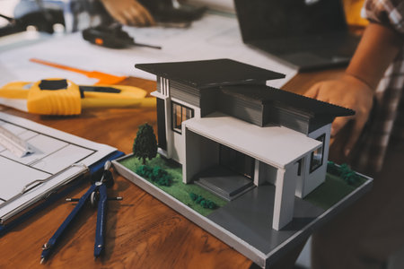 Construction and structure concept of engineer working drawing on blueprint meeting for project working with partner on model building and engineering tools in working site, construction concept.の写真素材