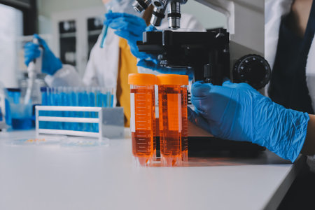 Collaboration, tablet or science with people in lab together for research or development. Innovation, tech and microscope with scientist team in clinical trial for planning or medical investigationの写真素材