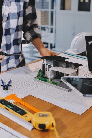 Construction and structure concept of engineer working drawing on blueprint meeting for project working with partner on model building and engineering tools in working site, construction concept.の写真素材