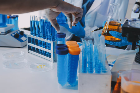 Collaboration, tablet or science with people in lab together for research or development. Innovation, tech and microscope with scientist team in clinical trial for planning or medical investigationの写真素材