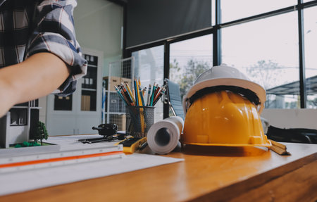 Construction and structure concept of engineer working drawing on blueprint meeting for project working with partner on model building and engineering tools in working site, construction concept.の写真素材