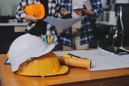 Construction and structure concept of engineer working drawing on blueprint meeting for project working with partner on model building and engineering tools in working site, construction concept.の写真素材