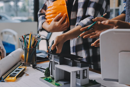 Construction and structure concept of engineer working drawing on blueprint meeting for project working with partner on model building and engineering tools in working site, construction concept.の写真素材