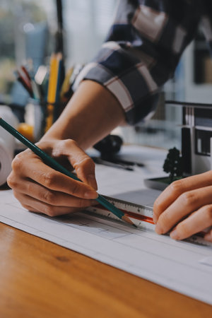 Construction and structure concept of engineer working drawing on blueprint meeting for project working with partner on model building and engineering tools in working site, construction concept.の写真素材