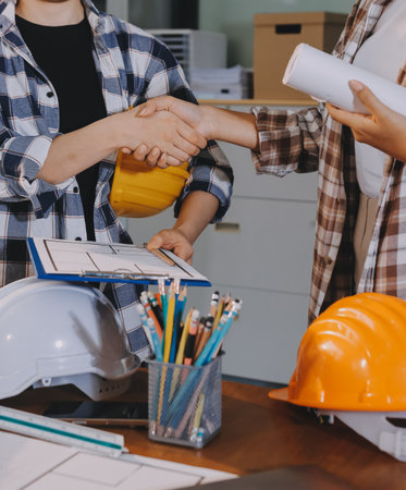 Construction and structure concept of engineer working drawing on blueprint meeting for project working with partner on model building and engineering tools in working site, construction concept.の写真素材