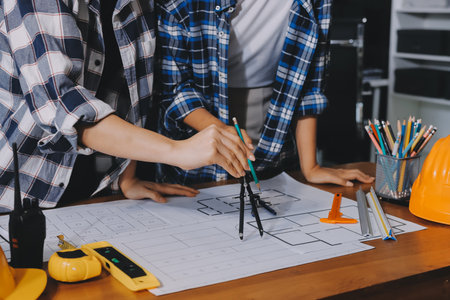 Construction and structure concept of engineer working drawing on blueprint meeting for project working with partner on model building and engineering tools in working site, construction concept.の写真素材