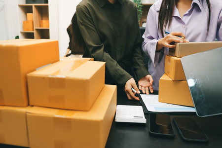 Portrait of Starting small businesses SME owners, two Asian woman check online orders Selling products working with boxs freelance work at home office, sme business online small medium enterpriseの写真素材
