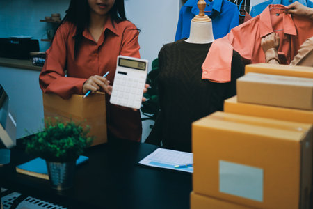 Portrait of Starting small businesses SME owners, two Asian woman check online orders Selling products working with boxs freelance work at home office, sme business online small medium enterpriseの写真素材