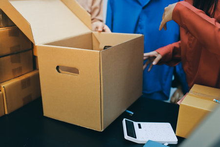 Portrait of Starting small businesses SME owners, two Asian woman check online orders Selling products working with boxs freelance work at home office, sme business online small medium enterpriseの写真素材