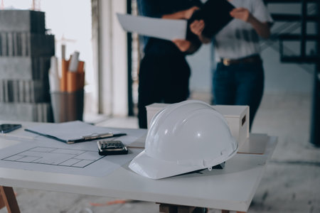 Construction manager and engineer explore construction documentation on the building site near the...