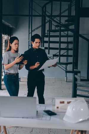 Construction manager and engineer explore construction documentation on the building site near the steel framesの写真素材