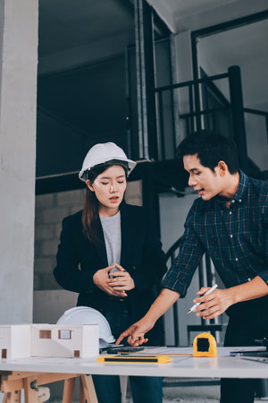 Construction manager and engineer explore construction documentation on the building site near the steel framesの写真素材