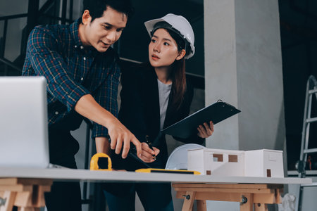 Construction manager and engineer explore construction documentation on the building site near the...