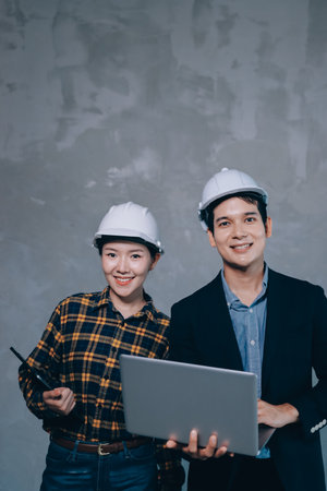Construction manager and engineer dressed in hard helmets explore construction documentation on the...