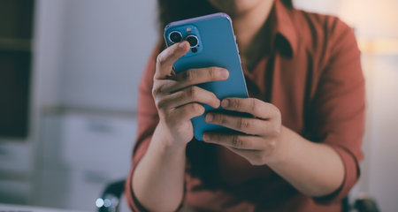 Closeup image of a businesswoman using mobile phone in officeの写真素材