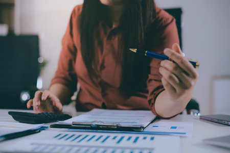 Portrait of young Hispanic professional business woman standing in office. Happy female company executive, smiling businesswoman entrepreneur corporate leader manager looking at camera using tabletの写真素材