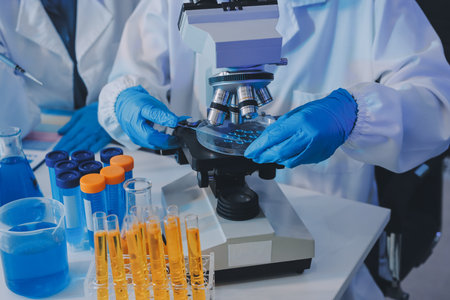 Collaboration, tablet or science with people in lab together for research or development. Innovation, tech and microscope with scientist team in clinical trial for planning or medical investigationの写真素材