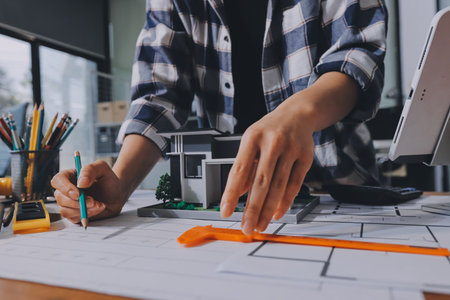 Construction and structure concept of engineer working drawing on blueprint meeting for project working with partner on model building and engineering tools in working site, construction concept.の写真素材