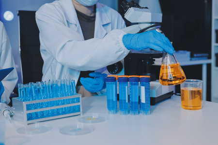 Collaboration, tablet or science with people in lab together for research or development. Innovation, tech and microscope with scientist team in clinical trial for planning or medical investigationの写真素材