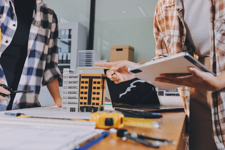 Construction and structure concept of engineer working drawing on blueprint meeting for project working with partner on model building and engineering tools in working site, construction concept.の写真素材