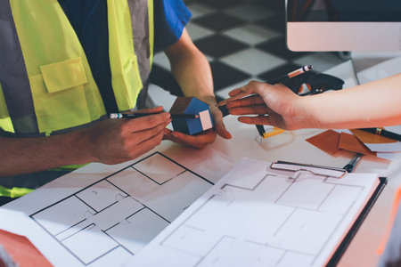 Closeup of team of industrial engineers meeting analyze machinery blueprints consult project on...
