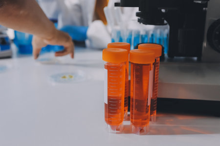 Collaboration, tablet or science with people in lab together for research or development. Innovation, tech and microscope with scientist team in clinical trial for planning or medical investigationの写真素材