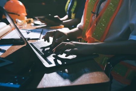 Closeup of team of industrial engineers meeting analyze machinery blueprints consult project on table in manufacturing factory. Working in manufacturing plant or production plant.の写真素材