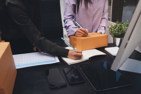 Portrait of Starting small businesses SME owners, two Asian woman check online orders Selling products working with boxs freelance work at home office, sme business online small medium enterpriseの写真素材