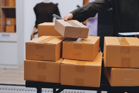 Portrait of Starting small businesses SME owners, two Asian woman check online orders Selling products working with boxs freelance work at home office, sme business online small medium enterpriseの写真素材