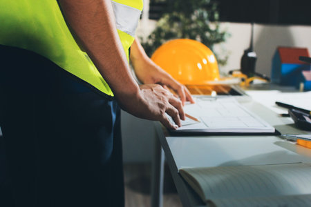 Closeup of team of industrial engineers meeting analyze machinery blueprints consult project on...