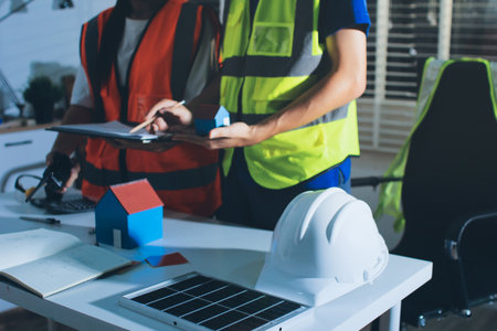 Closeup of team of industrial engineers meeting analyze machinery blueprints consult project on...