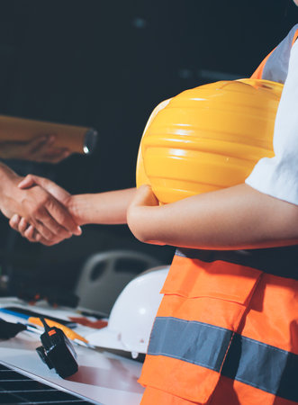 Closeup of team of industrial engineers meeting analyze machinery blueprints consult project on table in manufacturing factory. Working in manufacturing plant or production plant.の写真素材