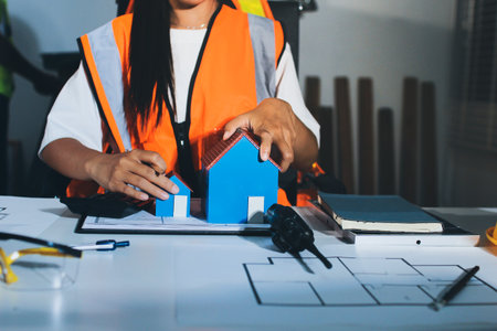 Closeup of team of industrial engineers meeting analyze machinery blueprints consult project on...