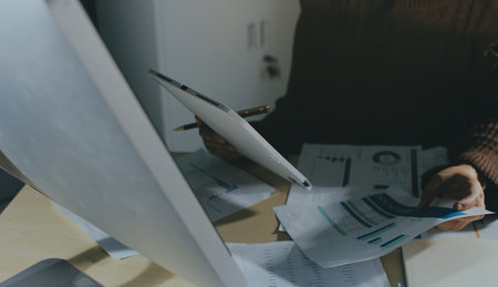 Close-up of businessman's hands making notes, chart, desk, office