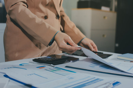 Close-up of businessman's hands making notes, chart, desk, office