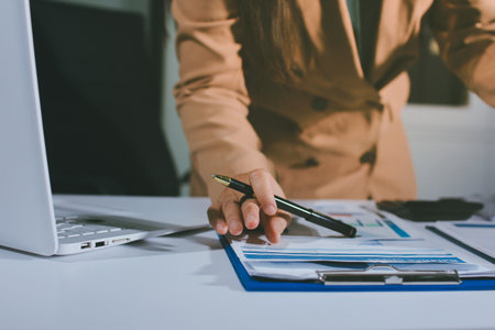 Close-up of businessman's hands making notes, chart, desk, officeの写真素材