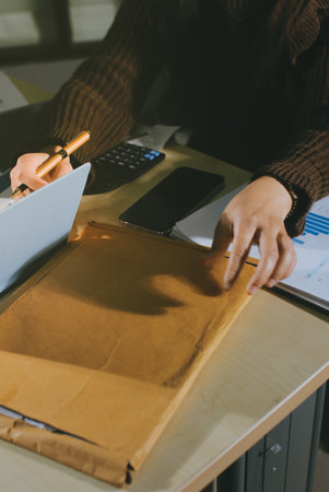 Close-up of hands making notes, chart, desk, officeの写真素材