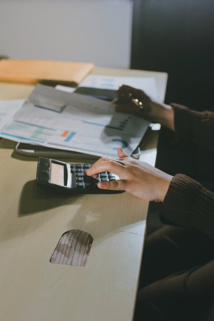 Close-up of businessman's hands making notes, chart, desk, office
