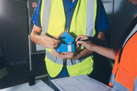 Closeup of team of industrial engineers meeting analyze machinery blueprints consult project on...