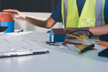 Closeup of team of industrial engineers meeting analyze machinery blueprints consult project on...