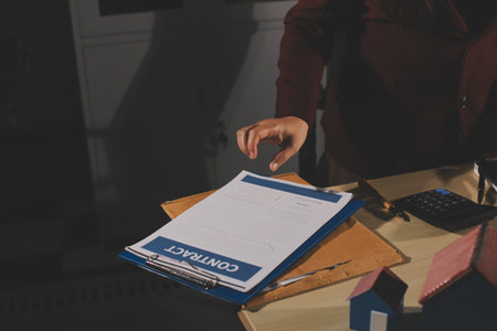 Customer signing a real estate contract in real estate agency.
