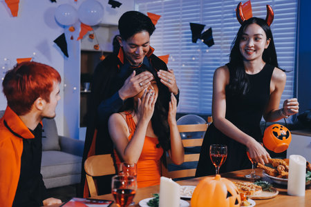 Joyful Halloween party with coworkers in costumes, celebrating with drinks and laughter, fostering teamwork and festive spiritの写真素材