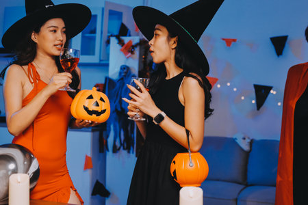 Joyful Halloween party with coworkers in costumes, celebrating with drinks and laughter, fostering teamwork and festive spiritの写真素材