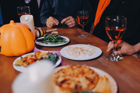 Joyful office Halloween party with coworkers in costumes, celebrating with laughter, fostering teamwork and festive spiritの写真素材