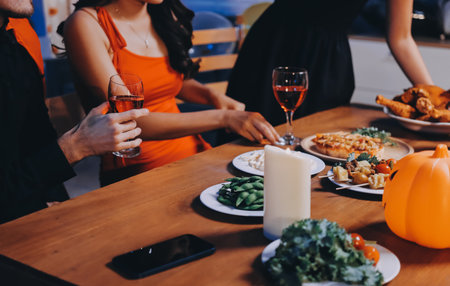 Joyful office Halloween party with coworkers in costumes, celebrating with drinks and laughter, fostering teamwork and festive spiritの写真素材