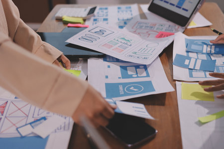 Close up ux developer and ui designer brainstorming about mobile app interface wireframe design on...
