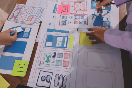 Close up ux developer and ui designer brainstorming about mobile app interface wireframe design on...
