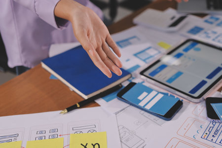 Close up ux developer and ui designer brainstorming about mobile app interface wireframe design on...