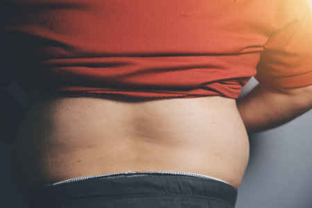 Asian man in front of a mirror looks at his body. Excess belly fat, Unhealthy lifestyle, Diet concept.の写真素材