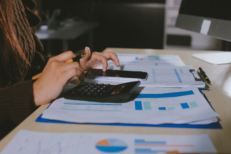 Close-up of businessman's hands making notes, mobiles, chart, desk, office